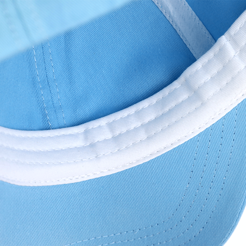 Closeup of a light blue custom baseball cap with white stitching and trim.